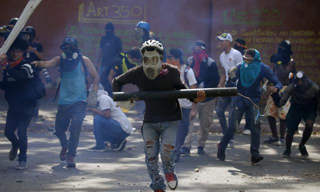La Guardia Nacional arrojó gases lacrimógenos contra cientos de personas que intentaban bloquear una autopista en proximidades de la base aérea La Carlota, donde un grupo de militares se sublevó contra Nicolás Maduro. (AP).