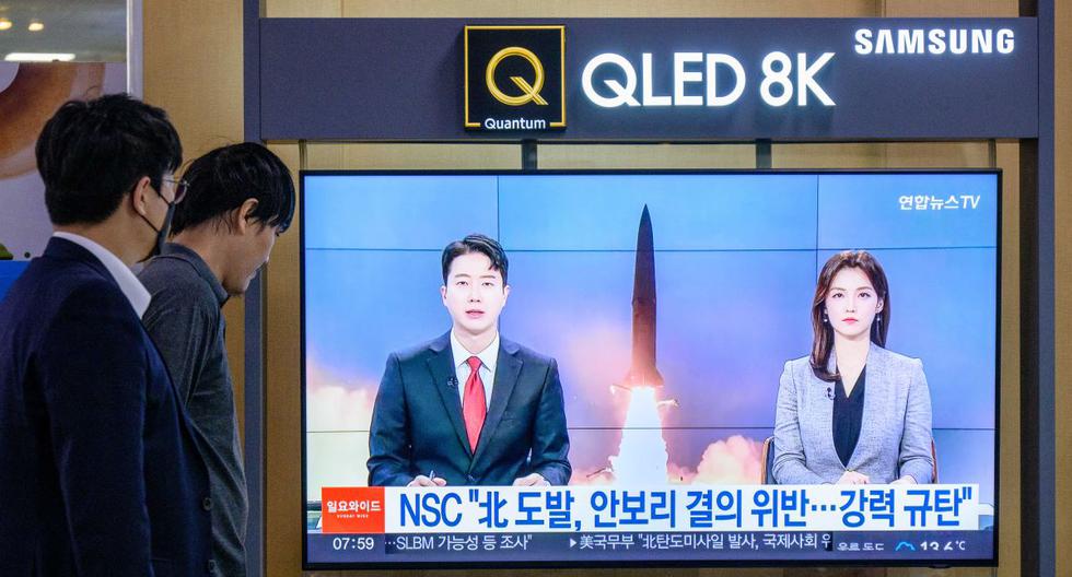 La gente mira una transmisión de noticias que muestra imágenes de archivo de una prueba de misiles de Corea del Norte, en una estación de tren en Seúl el 9 de octubre de 2022. (ANTHONY WALLACE / AFP).