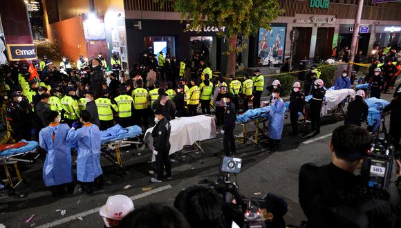 Los miembros del equipo de rescate esperan con camillas para retirar los cuerpos de la escena donde decenas de personas resultaron heridas en una estampida durante un festival de Halloween en Seúl, Corea del Sur.