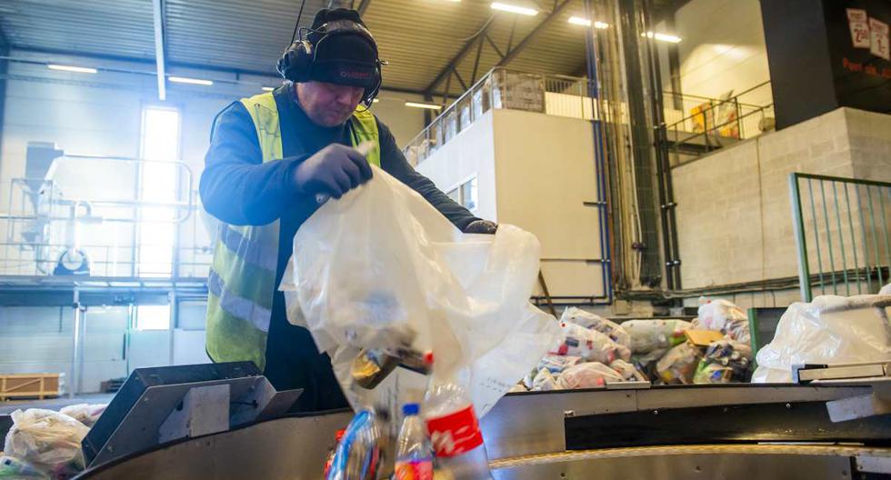 Un trabajador coloca botellas de plástico y aluminio en una máquina de la compañía Infinitum. (Foto: Fredrik Varfjell / AFP)