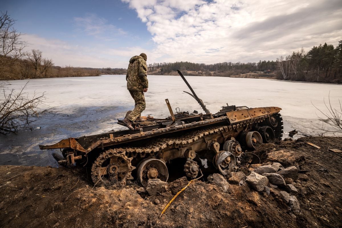 A Ukrainian serviceman stands near a destroyed Russian tank in the northeastern city of Trostyanets, Ukraine, on March 29, 2022. (FADEL SENNA / AFP)