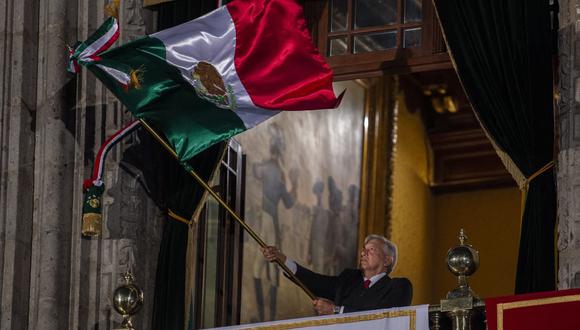 El presidente de México, Andrés Manuel López Obrador, ondea una bandera mexicana en el balcón principal del Palacio Nacional durante la ceremonia El Grito de la Independencia el 15 de septiembre de 2019. (PEDRO PARDO / AFP).