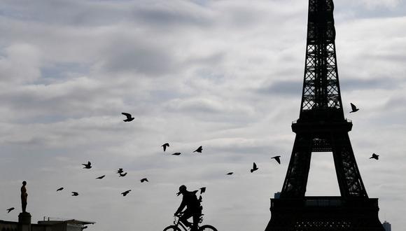 En esta foto de archivo tomada el 22 de marzo de 2020, un policía en bicicleta se va después de realizar controles a las personas en la explanada del Trocadero, cerca de la Torre Eiffel, en París (Francia). (FRANCK FIFE / AFP).