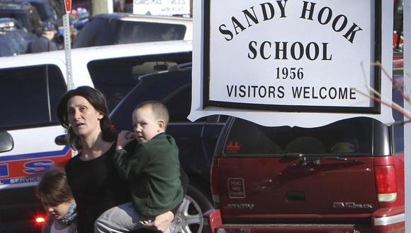 Una madre se aleja de la Escuela Primaria Sandy Hook con sus hijos luego de un tiroteo en en Newtown, Connecticut, el 14 de diciembre de 2012. (Frank Becerra Jr./The Journal News vía AP).