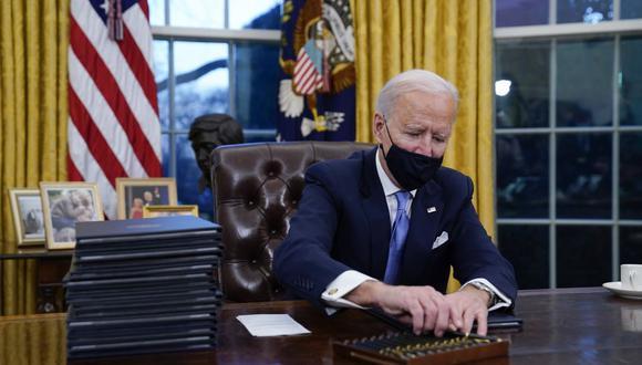 En esta fotografía de archivo del 20 de enero de 2021, el presidente Joe Biden toma un bolígrafo para una orden ejecutiva en la Oficina Oval de la Casa Blanca en Washington. (AP/Evan Vucci).