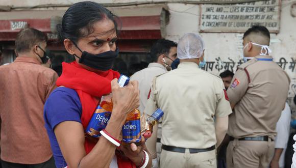 Imagen referencial. Mujer con una máscara de protección es vista en inmediaciones de una licorería en Nueva Delhi, India. (EFE/RAJAT GUPTA).