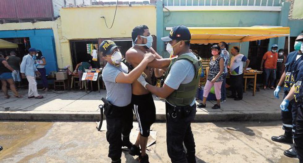 Dos policías portando mascarillas y guantes quirúrgicos intervienen a una persona en un mercado. (Foto referencial / Archivo / GEC)