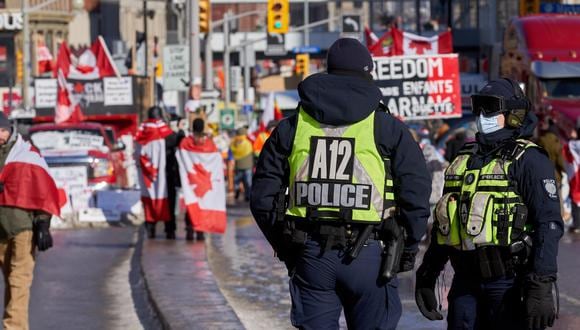 Policías observan a los manifestantes cerca de Parliament Hill en Ottawa, Ontario, Canadá, el 13 de febrero de 2022. (EFE/EPA/ANDRE PICHETTE).