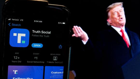 Esta ilustración fotográfica muestra una imagen del expresidente Donald Trump junto a la pantalla de un teléfono que muestra la aplicación Truth Social, en Washington, DC, el 21 de febrero de 2022. (STEFANI REYNOLDS / AFP).