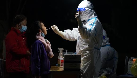 Los trabajadores médicos realizan pruebas de coronavirus en la ciudad de Xiian, provincia china de Shaanxi, el 23 de diciembre de 2021. (EFE / EPA / STRINGER).