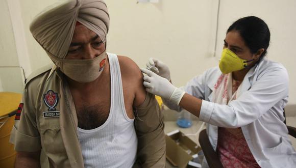 Una trabajadora médica inocula a un policía con una dosis de la vacuna contra el coronavirus de Covishield en un hospital civil en Amritsar, India, el 21 de abril de 2021. (Foto de NARINDER NANU / AFP).