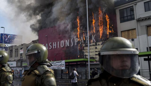 Violentos incidentes, incluido un incendio en una gran tienda comercial en el centro de Santiago provocado por manifestantes encapuchados, se registraron en Chile. (Foto: AFP)