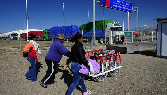 Migrantes venezolanos caminan en los alrededores de la aduana fronteriza en la frontera entre Bolivia y Chile, cerca de Pisiga, Bolivia, el 24 de marzo de 2022, mientras se dirigen a Colchane. , Chile. (Foto de Jorge Bernal / AFP)