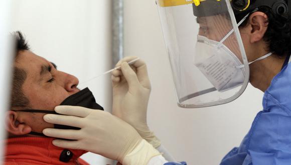 Un trabajador de la salud toma una muestra nasal de COVID-19 de un hombre para una prueba de PCR, luego de un aumento en las infecciones de Covid-19. (Foto: Cristina Vega RHOR / AFP)