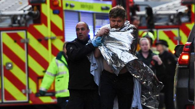 La policía ayuda a un hombre herido cerca del Puente de Londres en Londres. (Foto: AFP):