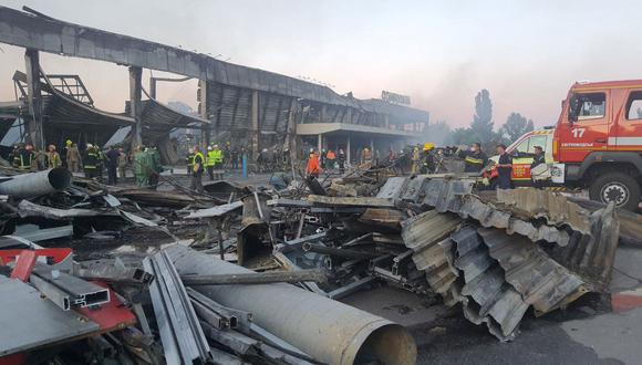 Rescatistas trabajan en el centro comercial afectado por un ataque con misiles rusos en la ciudad de Kremenchuk, en el este de Ucrania. (AFP).