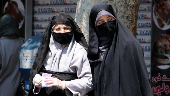 Mujeres iraníes usan mascarillas para intentar protegerse del coronavirus mientras caminan por una calle en Teherán, capital de Irán. (Foto: ATTA KENARE / AFP)