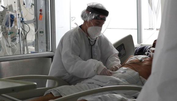 Una empleada de la salud atiende a un paciente en una unidad de cuidados intensivos para enfermos de covid-19 en el Hospital El Tunal, en Bogotá (Colombia). (Foto: EFE/Carlos Ortega).