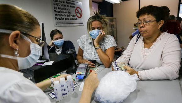 Ciudadanos venezolanos se apresuran a comprar desinfectantes para manos y máscaras frente a la pandemia mundial del coronavirus. (Foto: AFP).