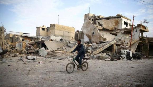 En la imagen, un hombre en bici pasa junto a edificios destruidos en la ciudad de Duma, en Guta Oriental, Siria. (Reuters)