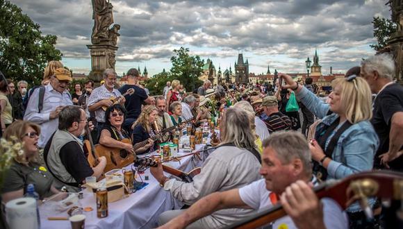 Coronavirus | Los músicos interactúan con los comensales  en el emblemático Puente de Carlos en Praga, República Checa. (EFE / EPA / MARTIN DIVISEK).