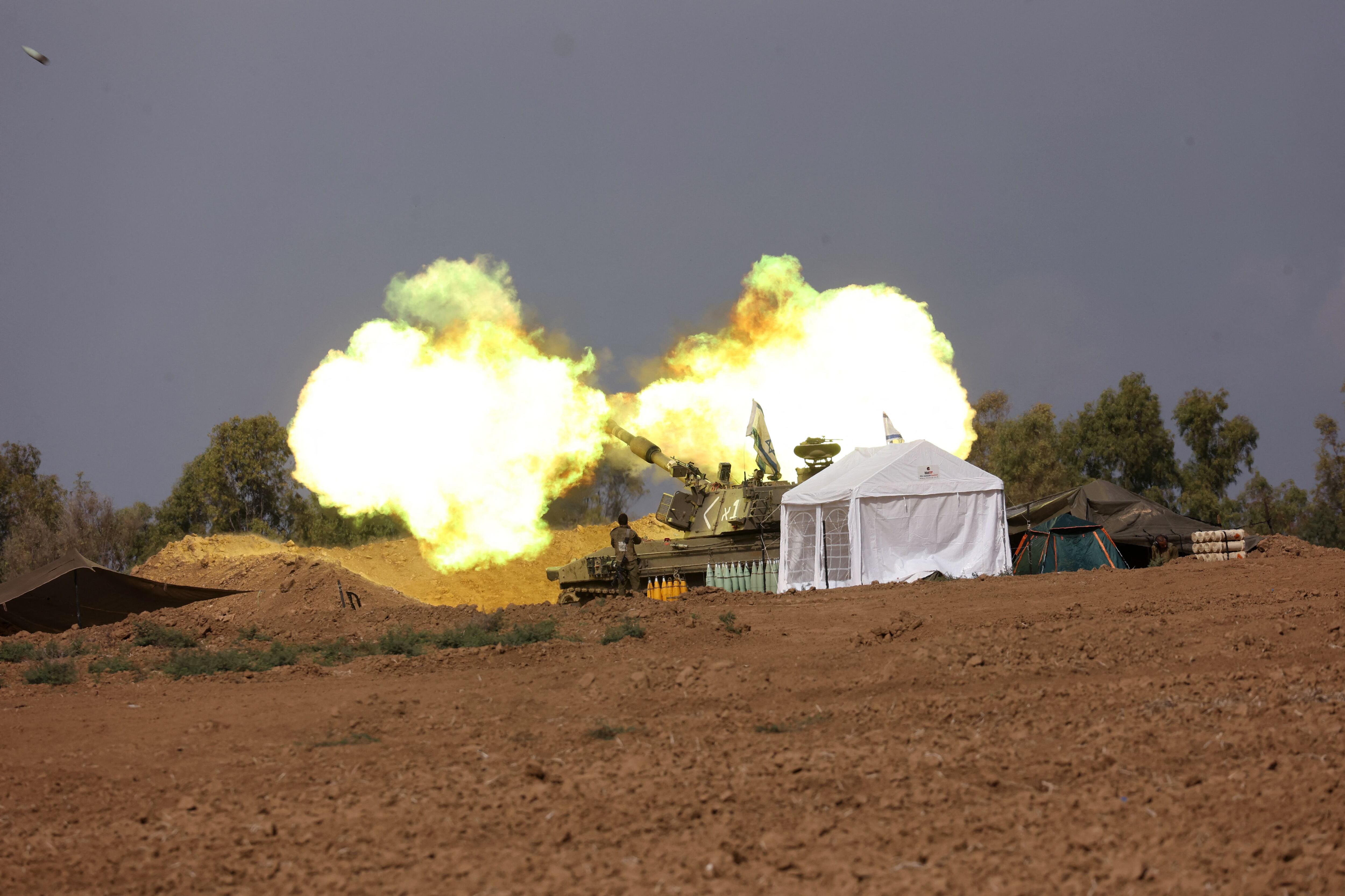 An Israeli artillery team fires from a field near the border with the Gaza Strip on November 14, 2023. (Photo by GIL COHEN-MAGEN/AFP).