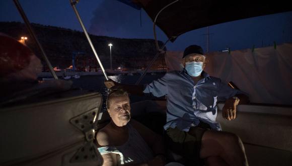 Margaretha Straates y Luis, de 80 y 90 años, esperan en su barco donde se han asentado tras huir de su casa tras la erupción del volcán Cumbre Vieja hace dos semanas. (Foto: JORGE GUERRERO / AFP)