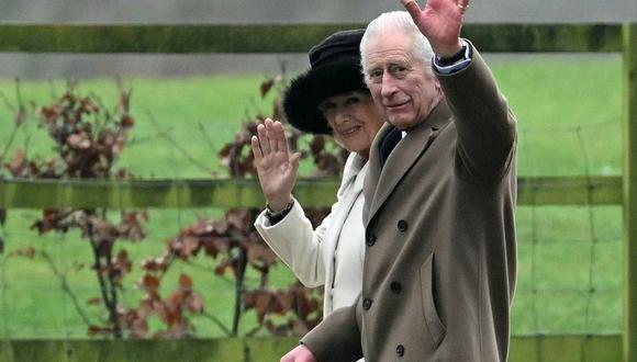 El rey Carlos III de Gran Bretaña y la reina Camilla de Gran Bretaña saludan tras asistir a un servicio en la iglesia de Santa María Magdalena en Sandringham Estate, en el este de Inglaterra, el 11 de febrero de 2024. (Foto de JUSTIN TALLIS / AFP)
