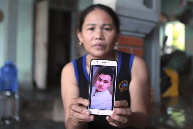 Hoang Thi Ai sostiene su teléfono mostrando una foto de su hijo Hoang Van Tiep. El joven es oriundo del distrito de Dien Chau, en la provincia de Nghe An. (Foto: AP).