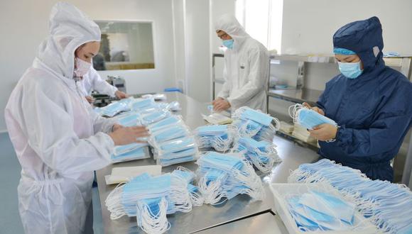Trabajadores de una fábrica en China empacan mascarillas ante la alta demanda por el brote de coronavirus.  Foto:  Archivo de AFP