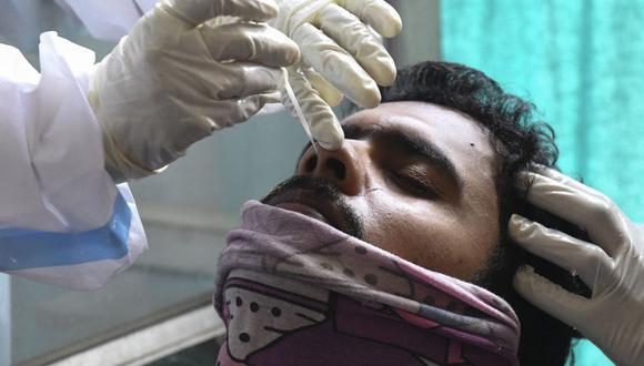 Un trabajador de la salud toma una muestra de un hisopo nasal a un hombre para realizar la prueba del coronavirus Covid-19 en Amritsar, India, el 21 de abril de 2021. (Foto de NARINDER NANU / AFP).