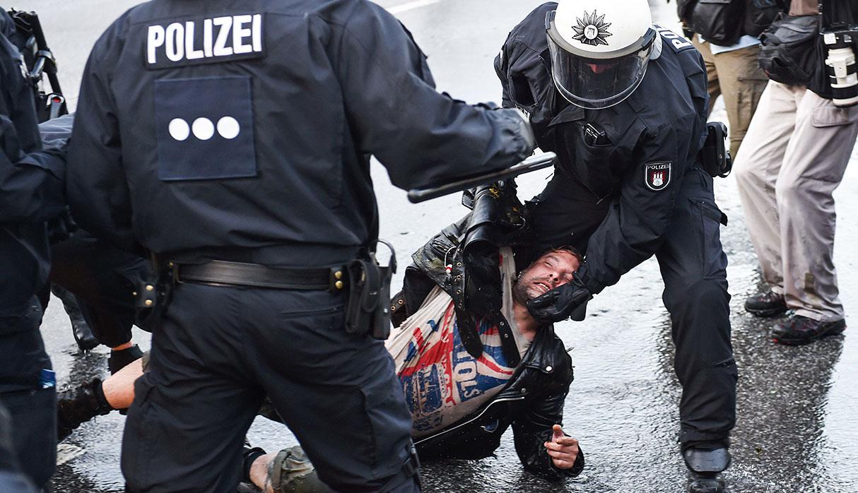 Riot police detain a protester during the "Welcome to Hell" rally against the G20 summit in Hamburg, northern Germany on July 6, 2017.  Leaders of the world's top economies will gather from July 7 to 8, 2017 in Germany for likely the stormiest G20 summit in years, with disagreements ranging from wars to climate change and global trade. / AFP / Christof Stache