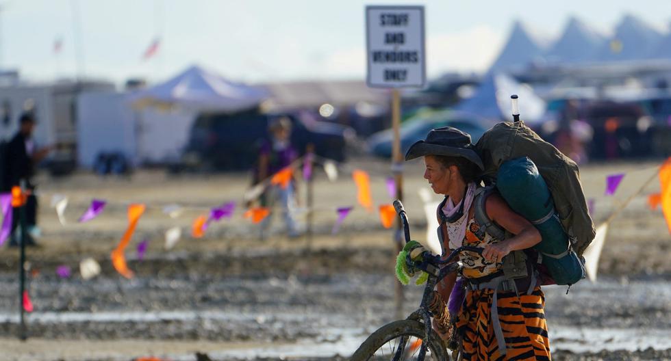 Un participante en el festival Burning Man camina con su bicicleta por el barro el 3 de septiembre de 2023. (Trevor Hughes/USA Today Network vía REUTERS).