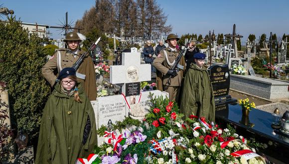 Soldados polacos resguardan la tumba de los Ulma mientras una multitud deja unas flores en honor a la familia que se sacrificó para esconder a judíos de los nazis durante la Segunda Guerra Mundial.