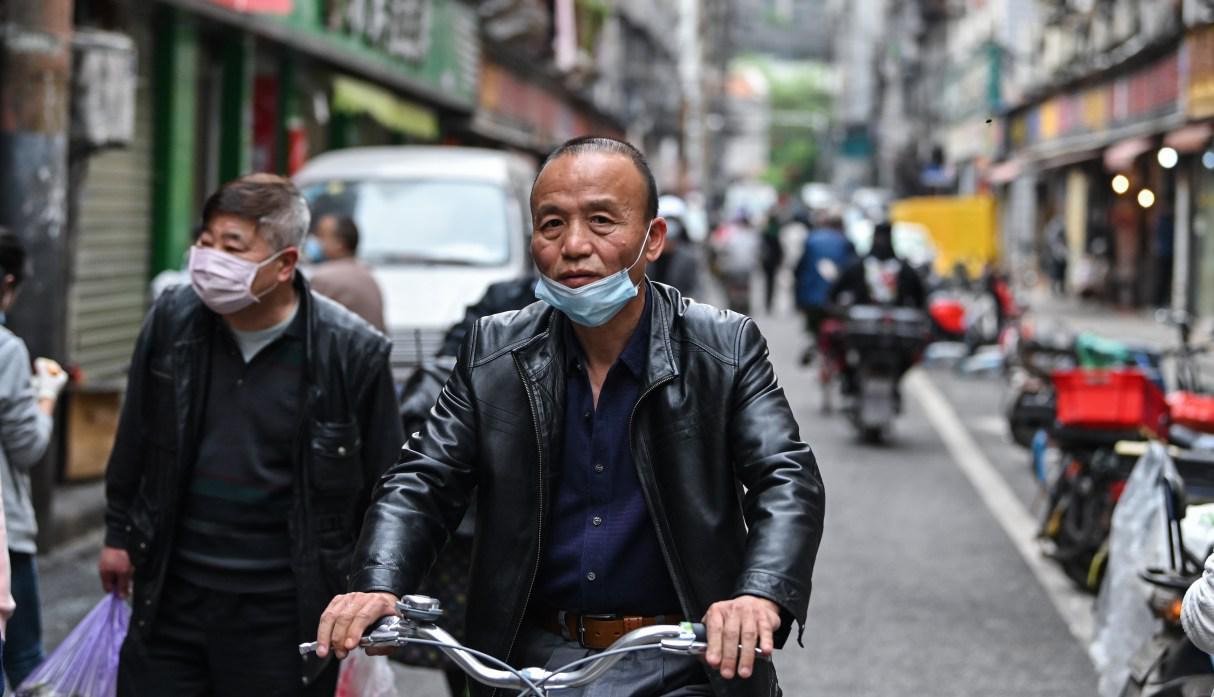 Un hombre es visto en una bicicleta en una calle de Wuhan, en la provincia central china de Hubei, el 8 de abril de 2020. (Héctor RETAMAL / AFP).