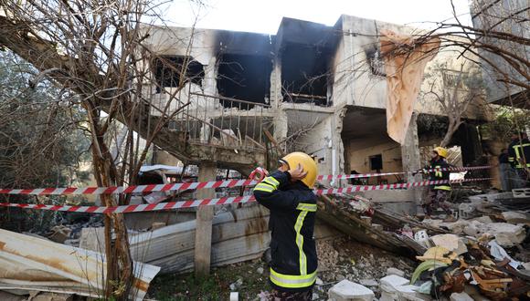 Un rescatista frente a un edificio dañado y quemado por las tropas israelíes durante una redada en el campo de refugiados de Yenín en Cisjordania, el 26 de enero de 2023. (Foto: JAAFAR ASHTIYEH / AFP)