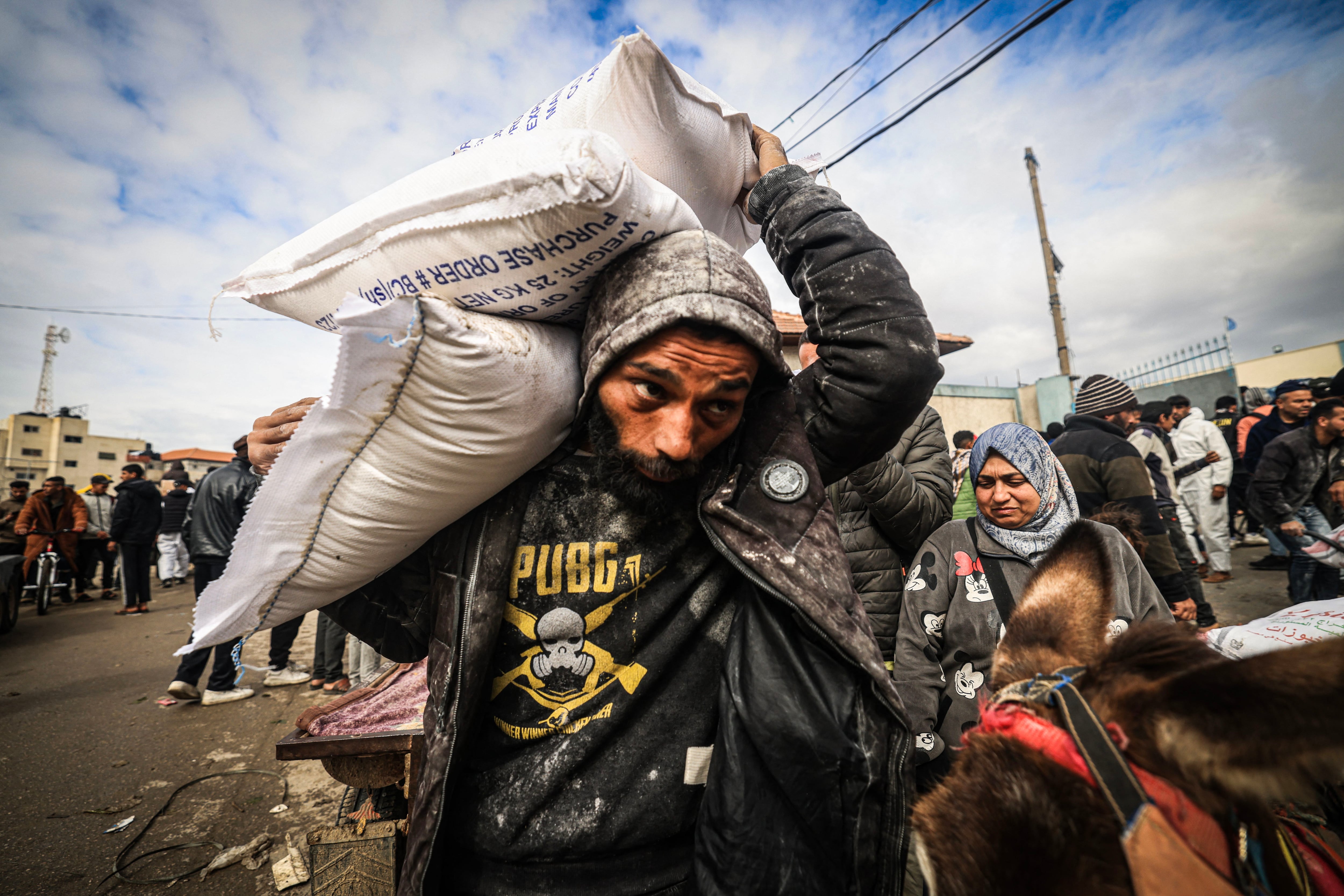 Displaced Palestinians receive food aid at the United Nations Relief and Works Agency for Palestine Refugees (UNRWA) center in Rafah, southern Gaza Strip, on January 28, 2024. (AFP Photo).
