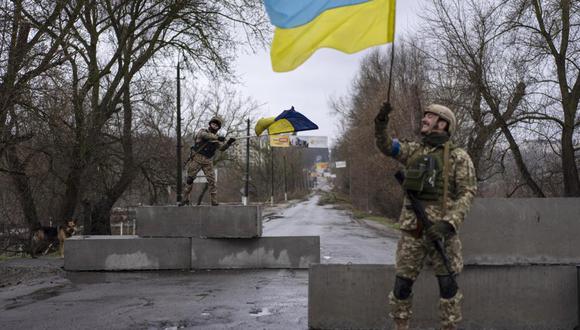 Un soldado ucraniano levanta una bandera de su país en Bucha, en las afueras de Kiev, el 3 de abril del 2022. Rusia sufrió un revés de proporciones históricas al no poder tomar la capital de Ucrania. (Foto AP/Rodrigo Abd, Archivo).
