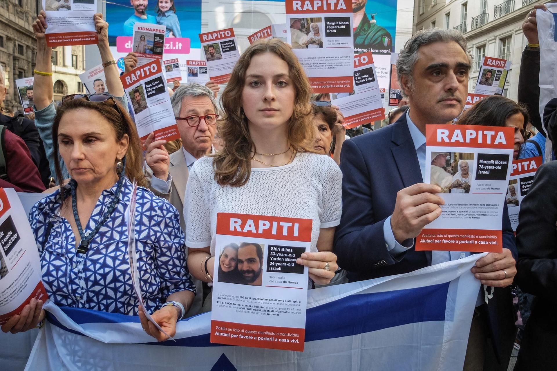 La gente lleva fotos de rehenes israelíes durante una manifestación para exigir su liberación, en Milán, Italia, el 3 de junio de 2024. (EFE/EPA/MATTEO CORNER).