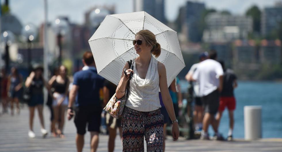 Un imagen de archivo de una mujer llevando un paraguas para protegerse del sol en Sydney. (AFP)