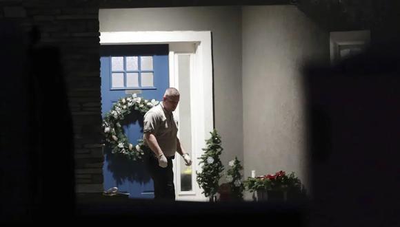 Un oficial de policía se encuentra cerca de la puerta principal de la casa de Enoch, Utah, donde ocho miembros de la familia fueron encontrados muertos por heridas de bala. (Ben B. Braun/The Deseret News vía AP).