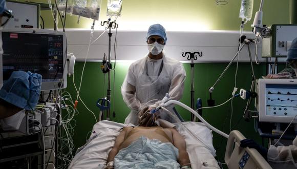 Un médico atiende a un paciente de coronavirus Covid-19 en la unidad de cuidados intensivos del hospital Lyon-Sud en Pierre-Benite, en Francia, el 8 de septiembre de 2021. (JEFF PACHOUD / AFP).