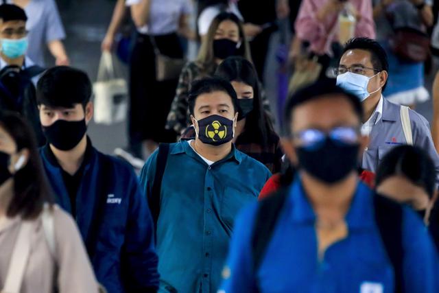 Viajeros con máscaras protectoras por el coronavirus caminan por un paso elevado en Bangkok, Tailandia. (EFE/EPA/DIEGO AZUBEL).