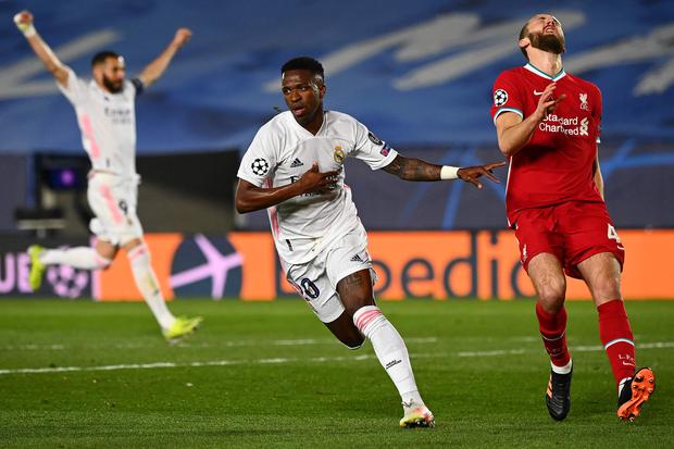 TOPSHOT - Real Madrid's Brazilian forward Vinicius Junior (C) celebrates after scoring a goal during the UEFA Champions League first leg quarter-final football match between Real Madrid and Liverpool at the Alfredo di Stefano stadium in Valdebebas in the outskirts of Madrid on April 6, 2021.
 / AFP / GABRIEL BOUYS
