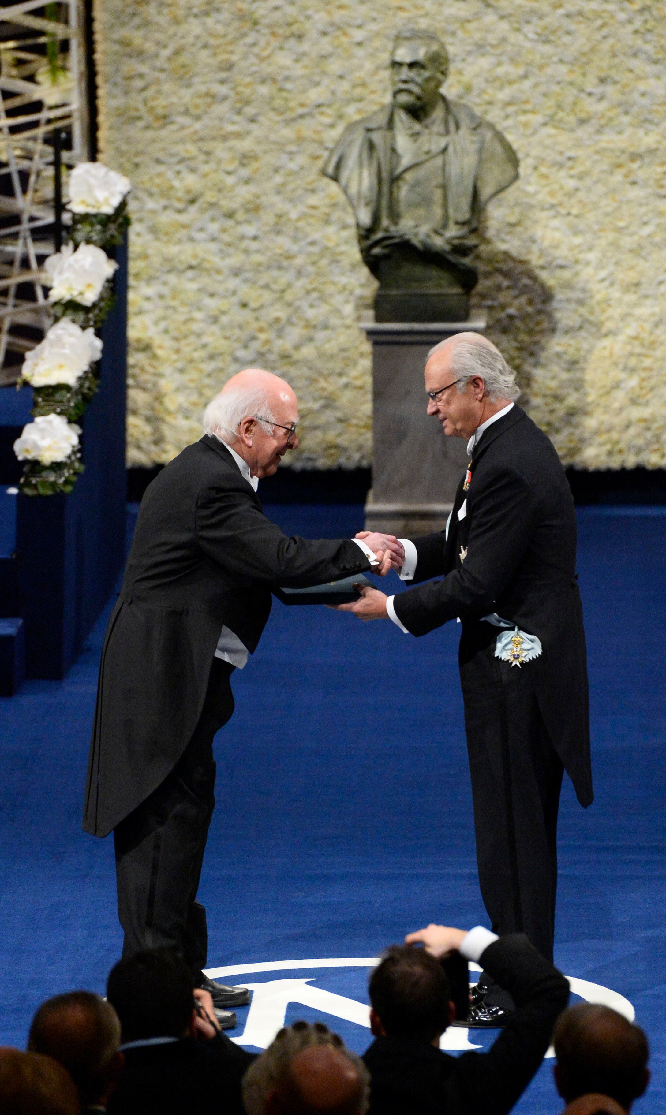 Peter Higgs recibe su premio de manos del rey Carlos XVI Gustavo de Suecia. (Foto: AFP)