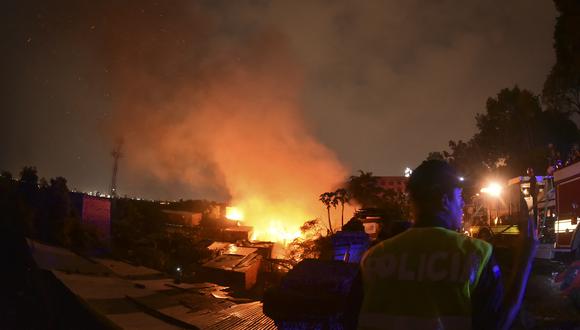 Un policía trabaja durante un gran incendio en el barrio Ricardo Brugada, conocido como "La Chacarita", en las inmediaciones del Cabildo de Asunción el 6 de octubre de 2023. (Foto de Daniel DUARTE / AFP)