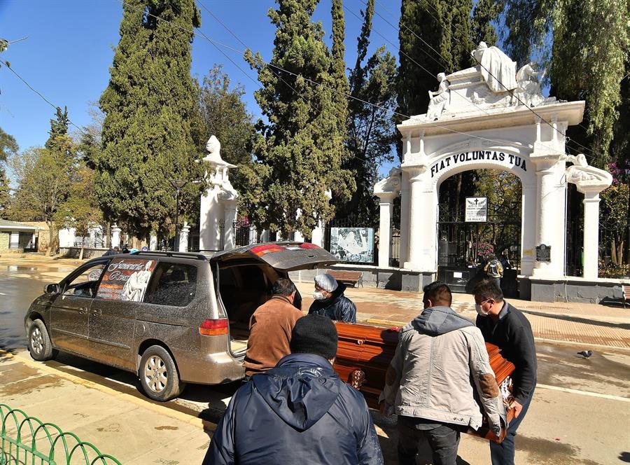 Familiares retiran un féretro de un cementerio cerrado, este lunes en Cochabamba (Bolivia). (EFE/Jorge Ábrego).