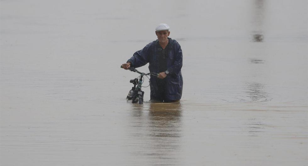 Un hombre cruza con su bicicleta una calle inundada debido a lluvias causadas por el huracán Fiona en Toa Baja, Puerto Rico. (EFE/Thais LLorca).