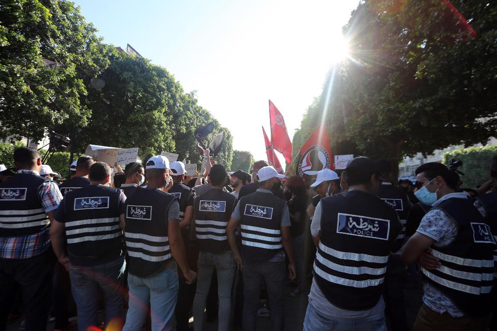 Las fuerzas policiales se reúnen mientras manifestantes tunecinos contra el gobierno gritan consignas durante una protesta contra la violencia policial en Túnez. La gente organizó una manifestación para protestar por la muerte de un joven , quien presuntamente murió luego de ser golpeado por agentes del orden mientras estaba bajo custodia. (Foto: EFE)