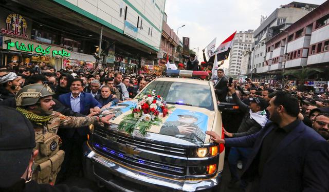 Miles de personas rodean el vehículo donde está los restos del general iraní Qasem Soleimani, asesinado en Irak por un dron de Estados Unidos. (AFP / SABAH ARAR).